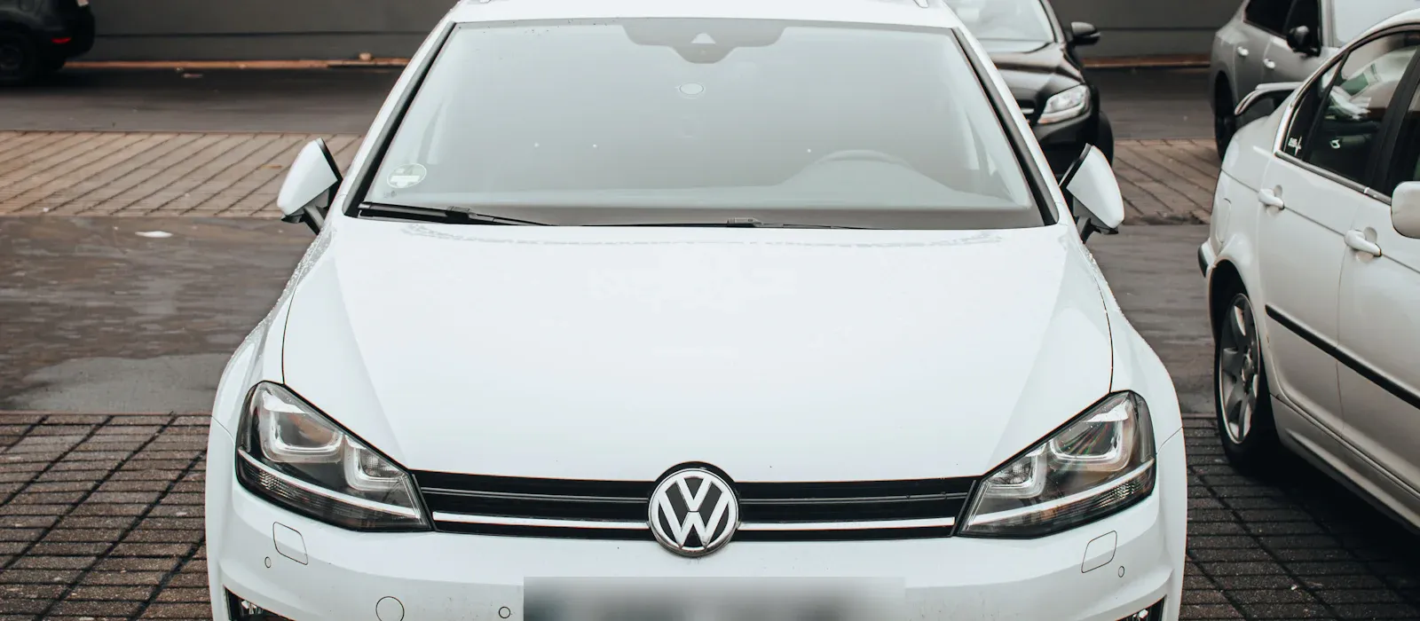 Weißer Kombi mit deutschem Kennzeichen auf einem Parkplatz